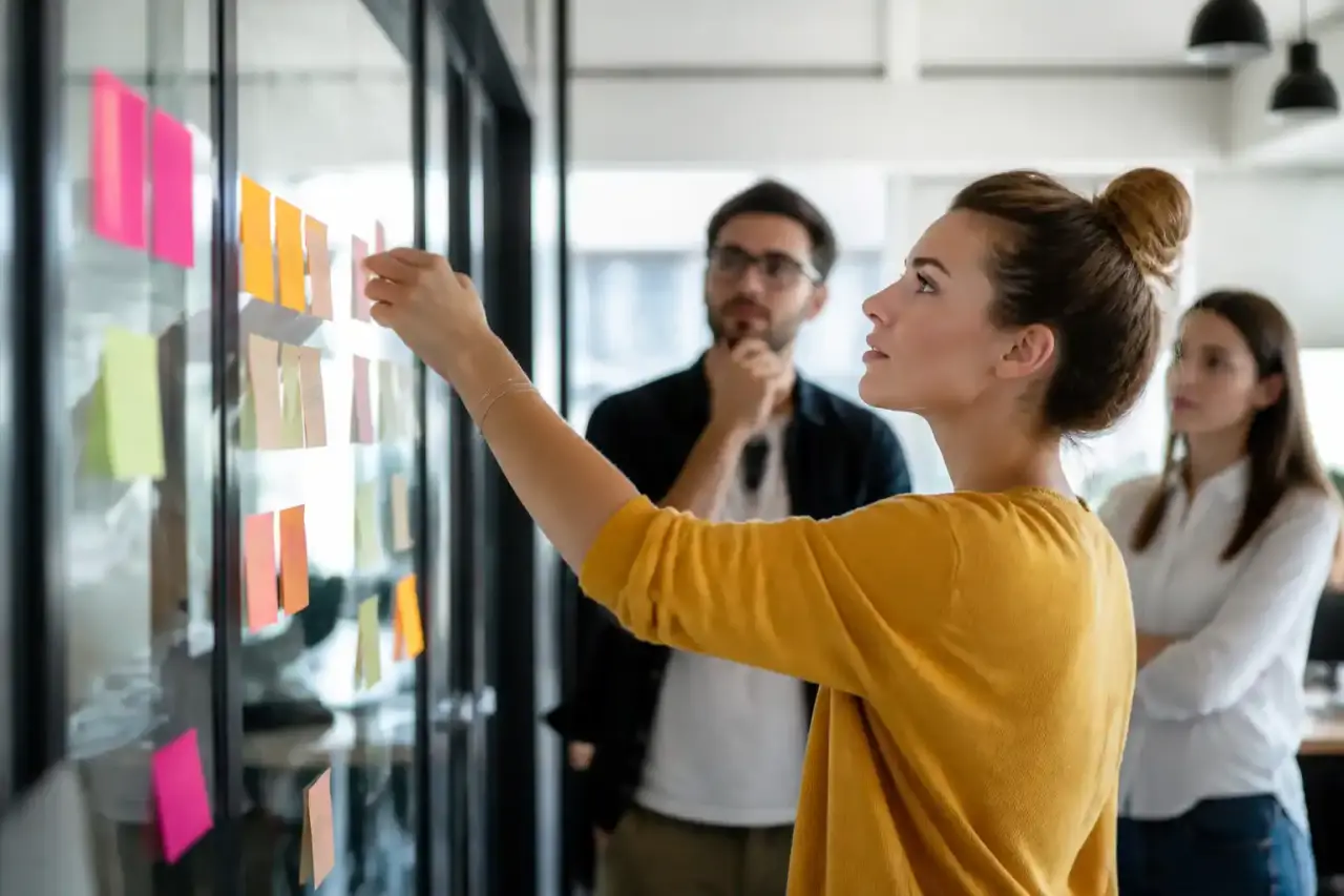 Équipe en réunion agile autour d'un tableau visuel en entreprise